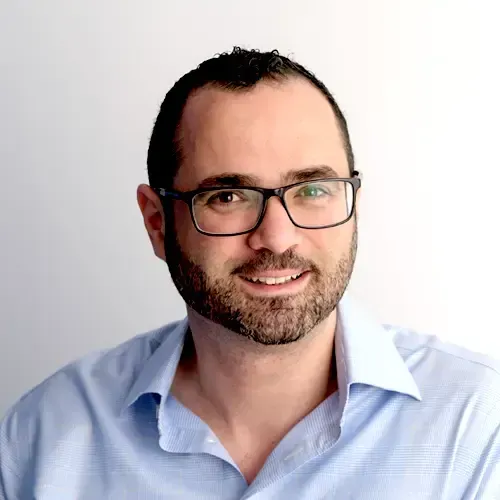 A man with a beard and glasses is smiling for the camera.