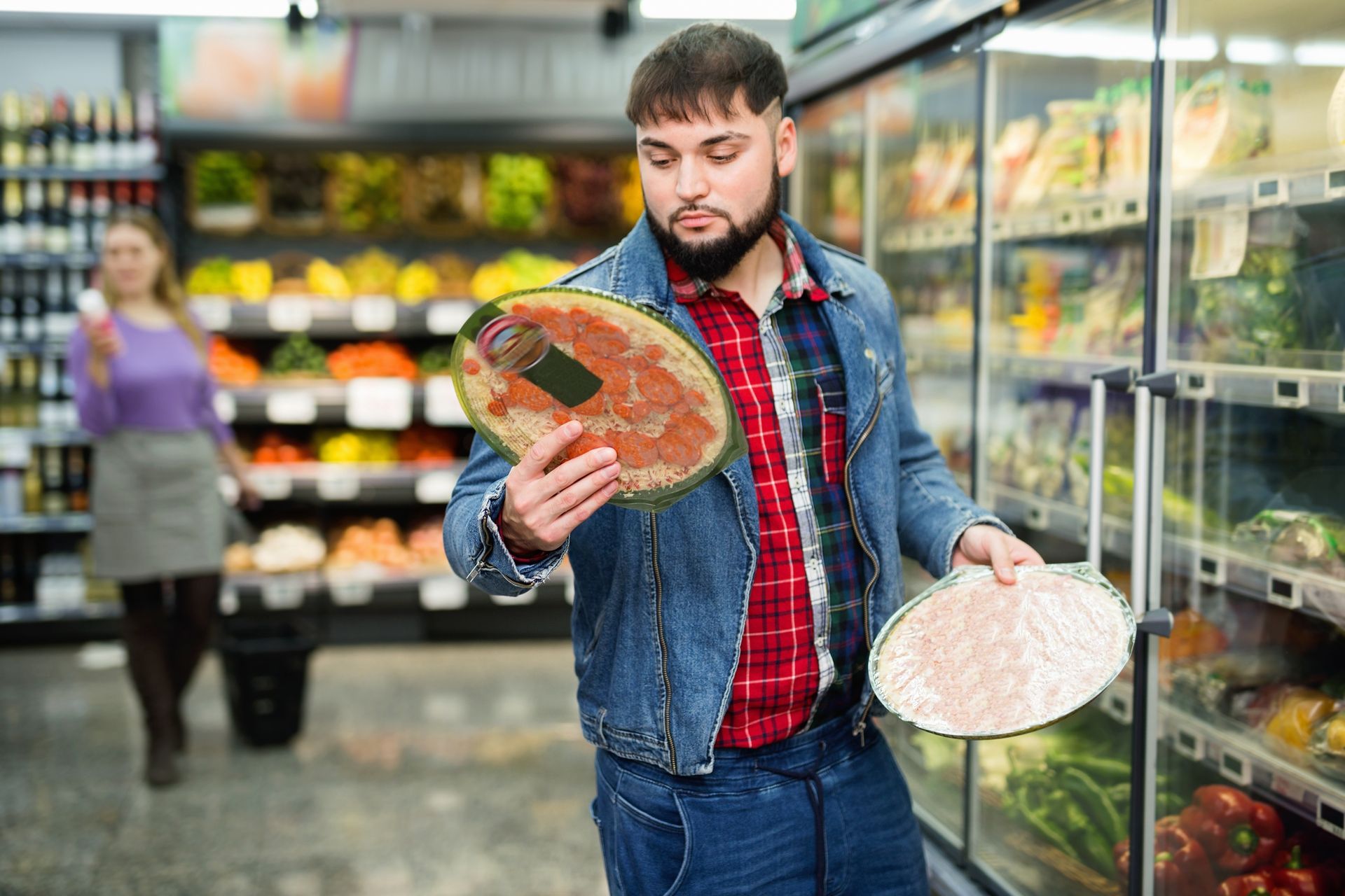 We all need to make wise choices. A man in a supermarket is holding up a pizza.