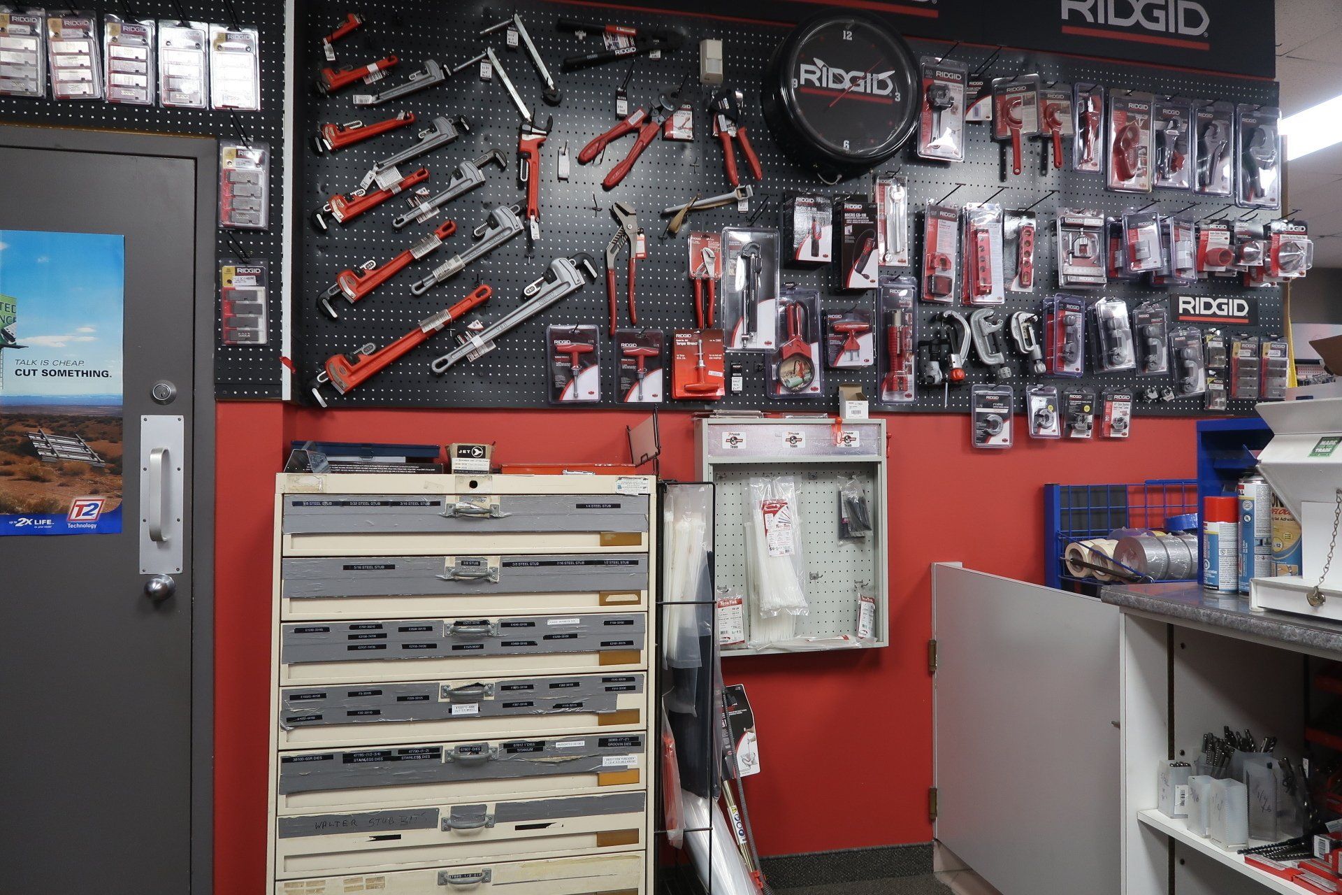 Une pièce avec beaucoup d'outils sur le mur et une commode.