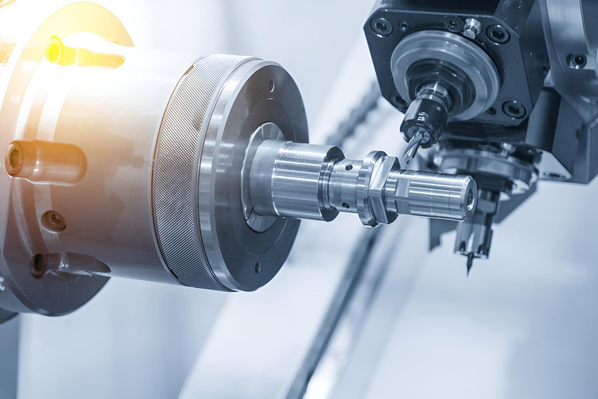 Industrial robotic arm machining a metal shaft in a factory setting