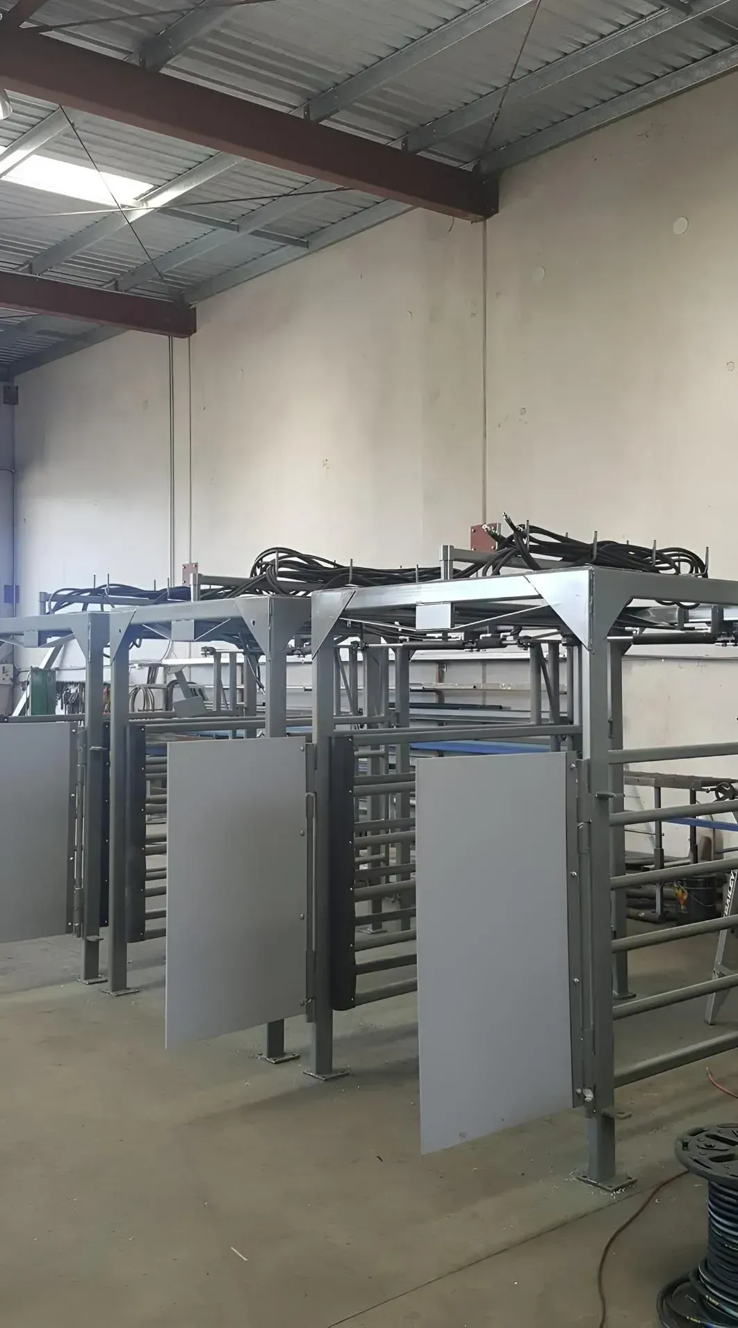 Industrial room with metal racks and equipment arranged in rows under a high ceiling