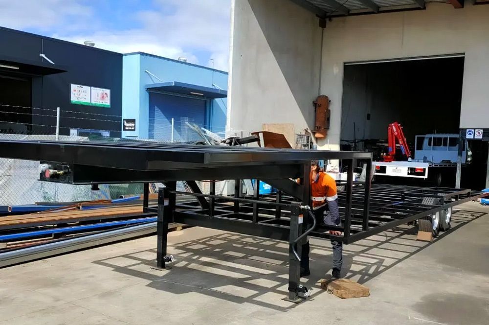 Worker inspecting large metal platform beside warehouse loading dock