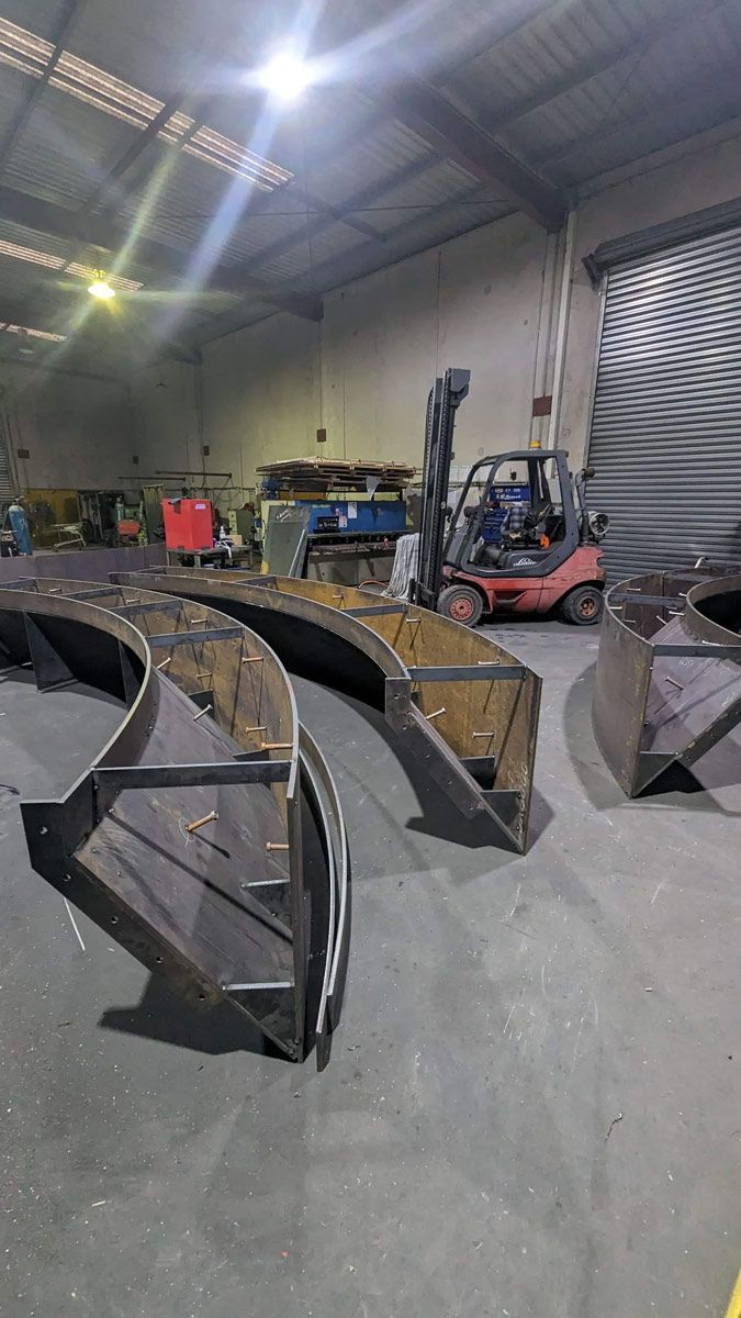 Warehouse with metal buckets and a forklift under bright overhead lights
