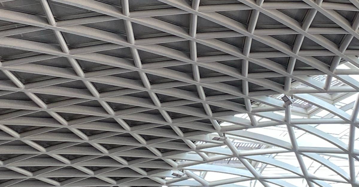 Geometric steel lattice ceiling with skylights and white beams inside a modern building