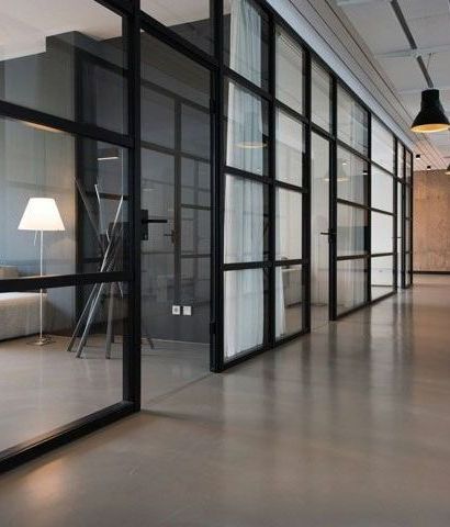A long hallway with a lot of windows and a lamp.