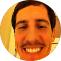 A man with a mustache is smiling in a circle.