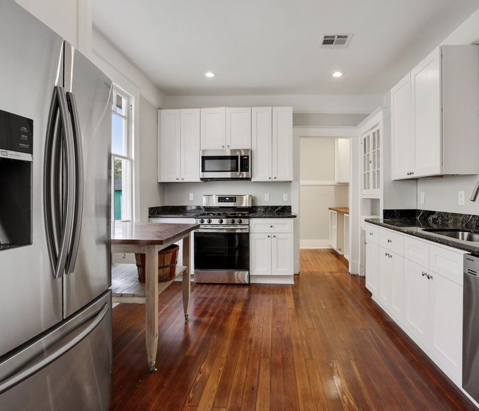 A kitchen with stainless steel appliances and white cabinets