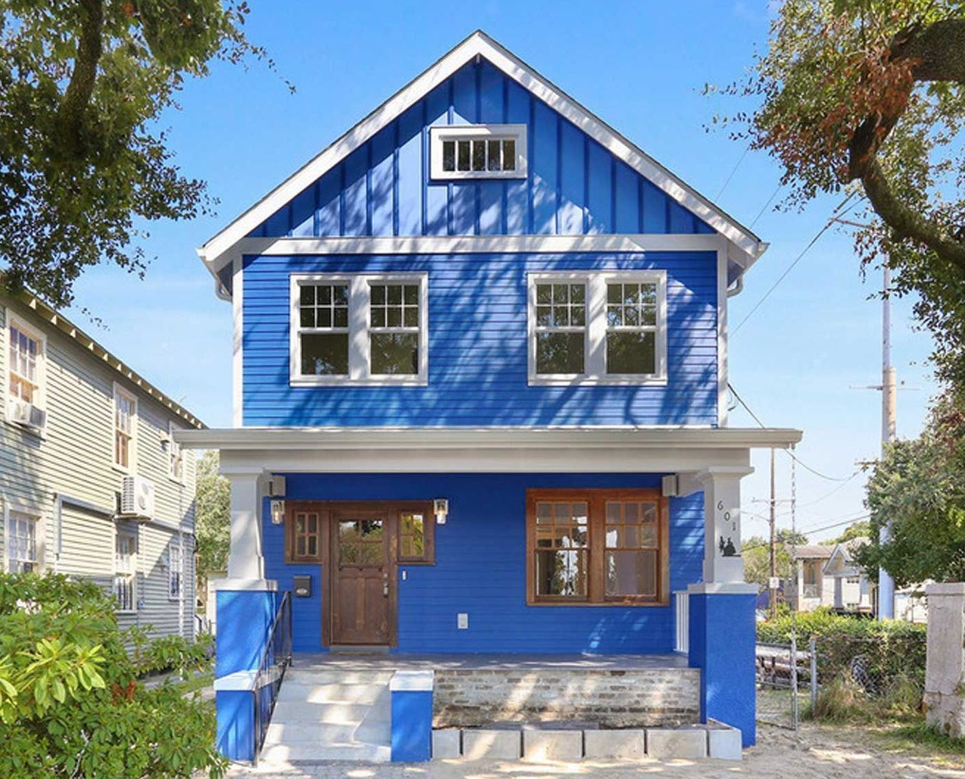 A blue house with white trim and a white roof