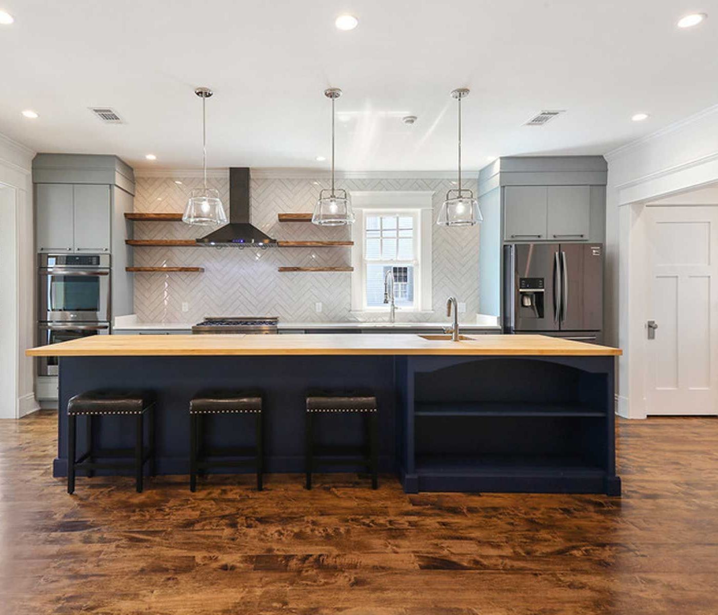 Modern kitchen remodel in New Orleans with large island, custom cabinetry, and open layout by Sweene