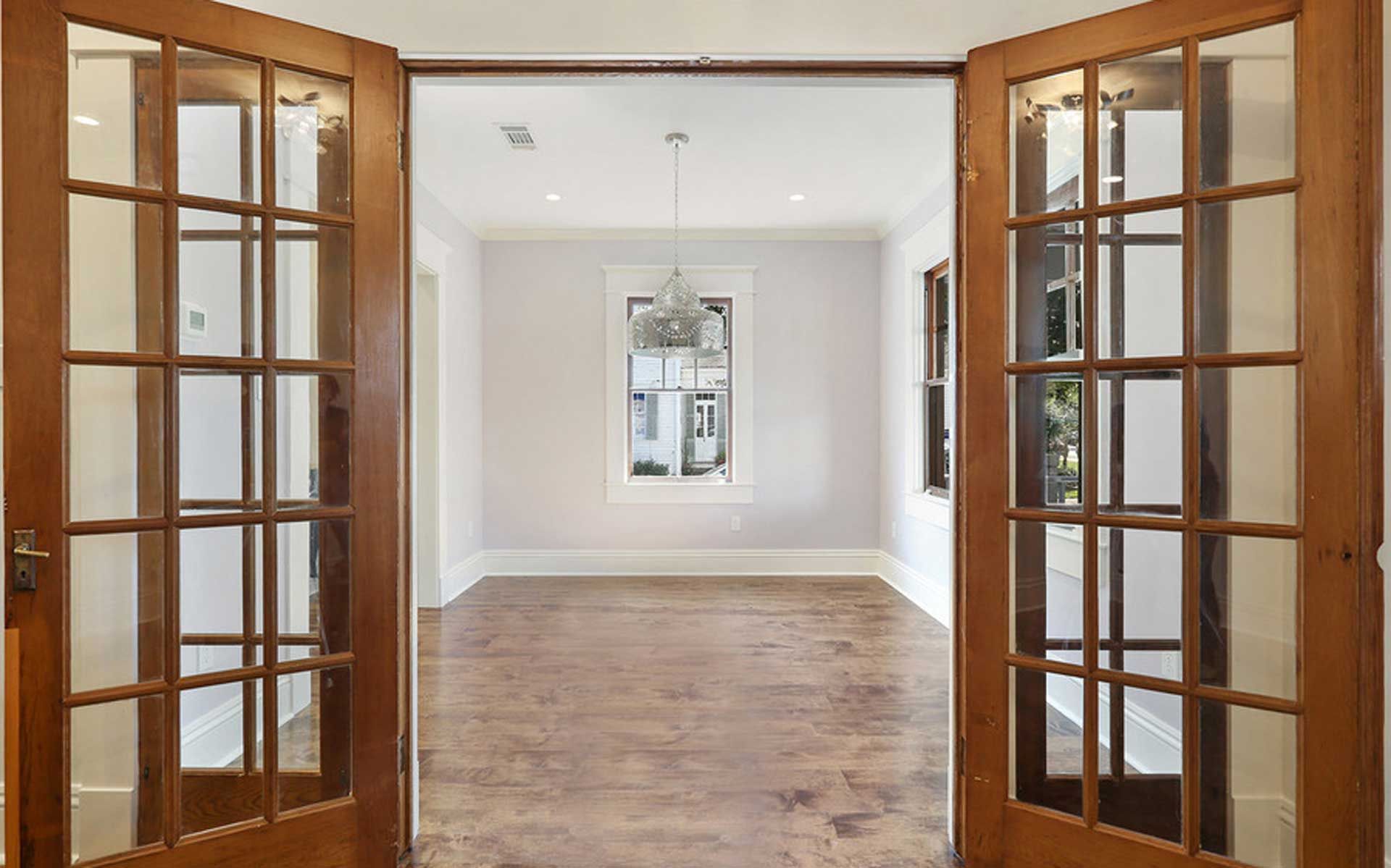 An empty room with french doors and a window.