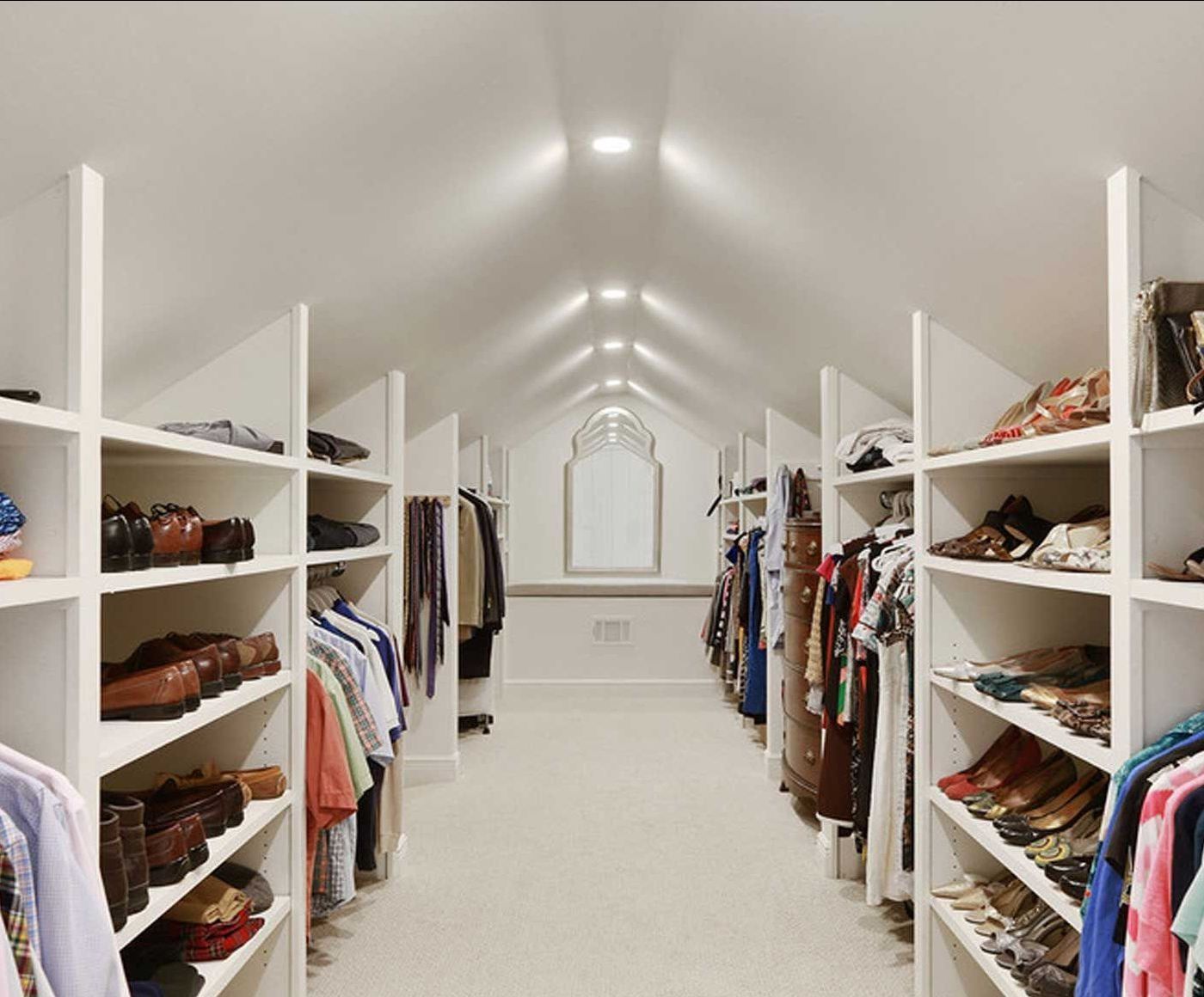 A spacious, bright walk-in closet with built-in shelves and clothing racks.
