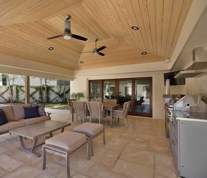 A living room with a table and chairs and a ceiling fan