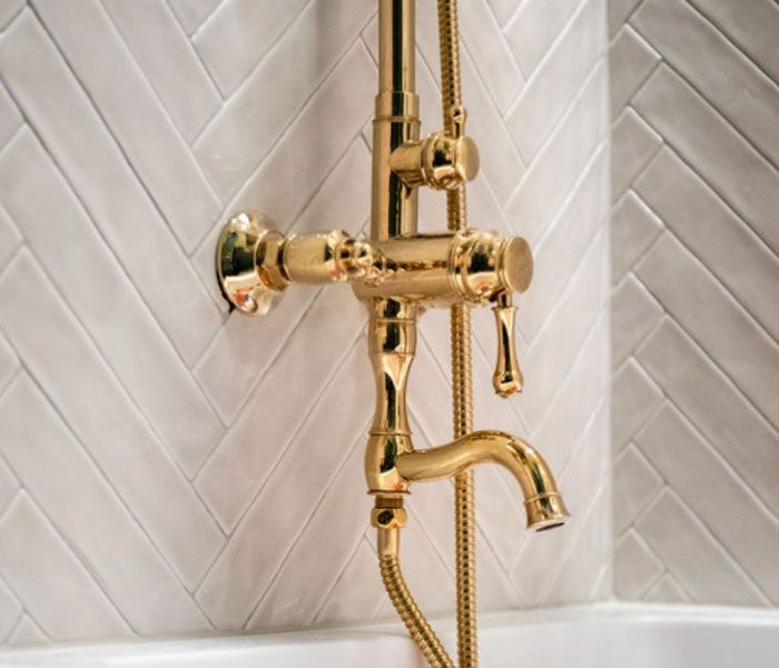 A gold shower head with a hose attached to it