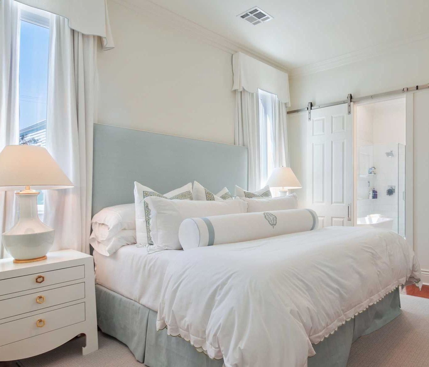 A bedroom with a king size bed and two lamps
