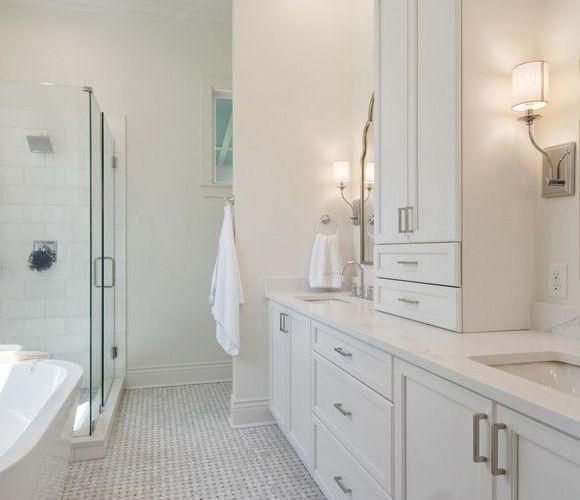 A bathroom with white cabinets and a bathtub