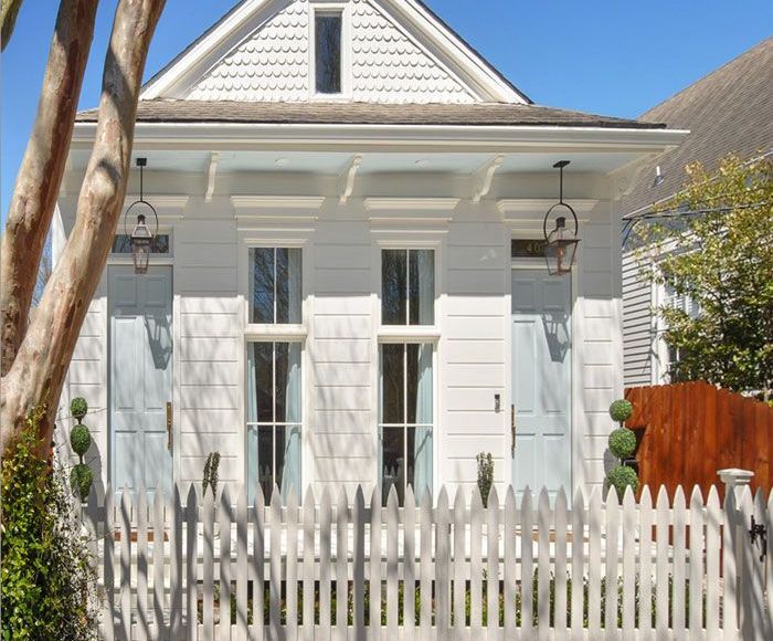 A white house with a white picket fence in front of it