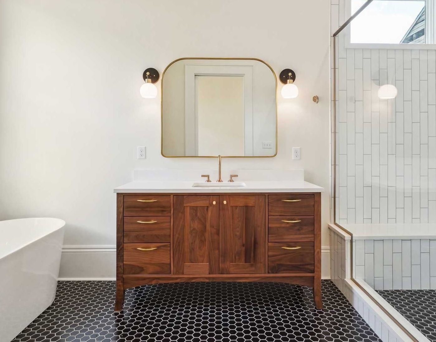 A bathroom with a wooden vanity and a large mirror