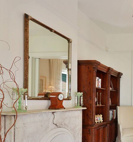 A fireplace with a mirror and a clock on it