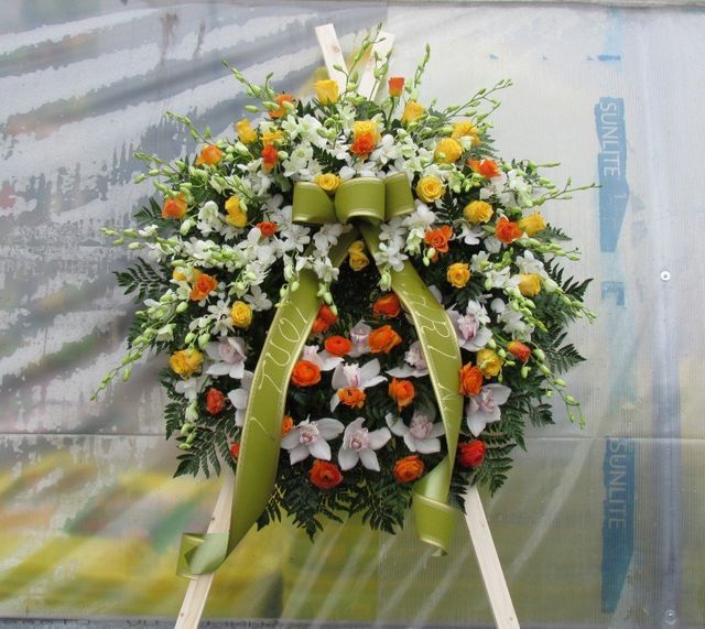 Una corona funebre floreale circolare composta da orchidee bianche