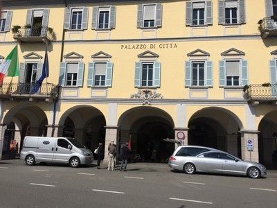 Un edificio giallo adibito a municipio in stile italiano, con passaggi ad arco