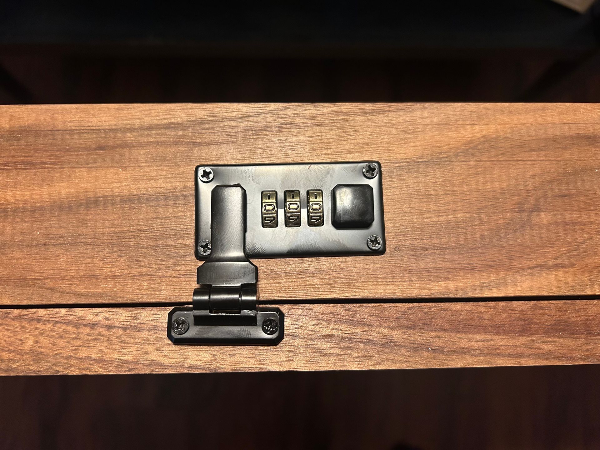 Wooden box with a black combination lock.