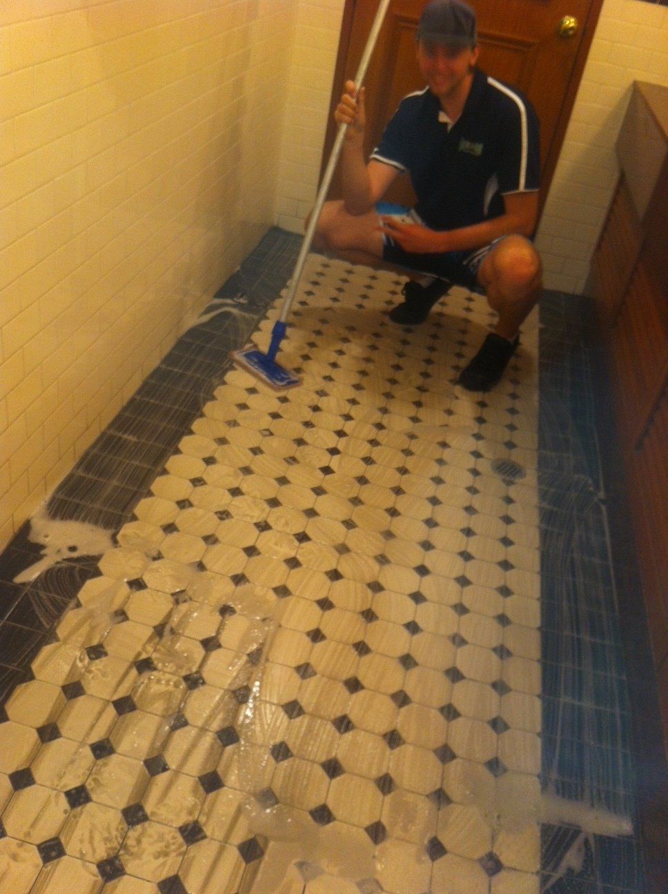 Male Worker Removing Dirt from Tiles — Enviro Clean Carpet and Tile Cleaning in Woy Woy, NSW