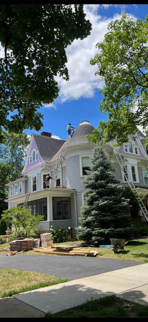 A man is working on the roof of a house.