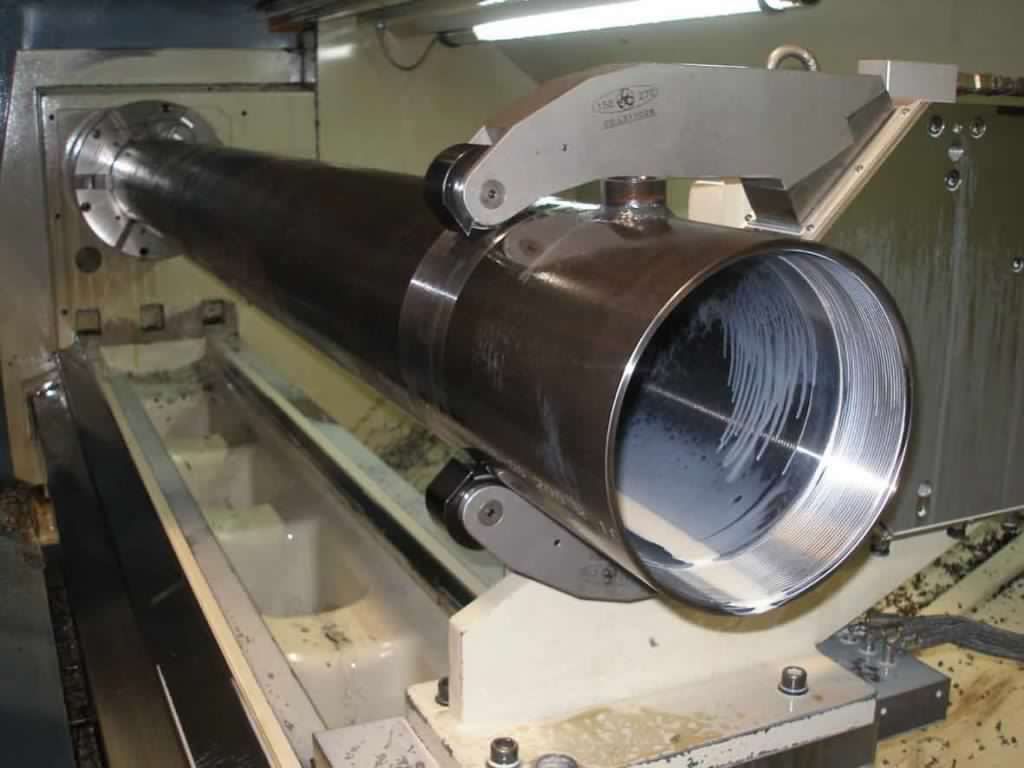 grosso tubo cilindrico metallico montato su una macchina