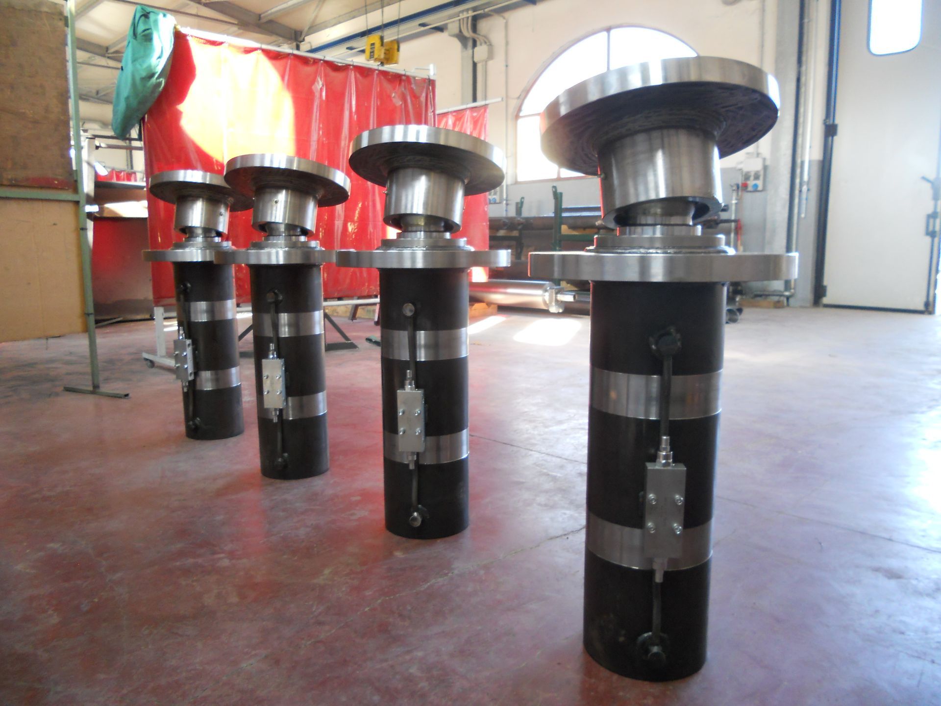 Quattro componenti metallici industriali