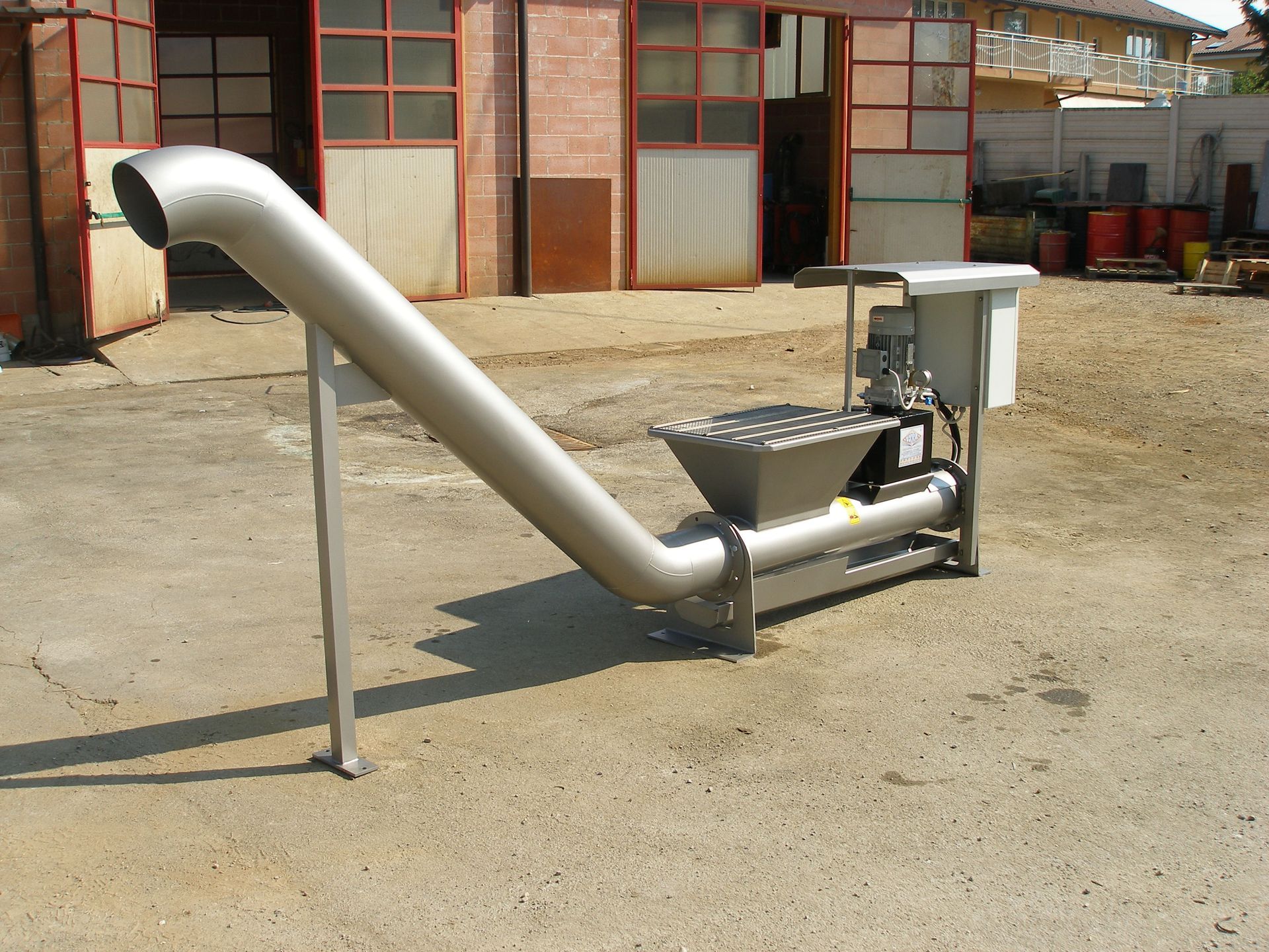 Macchina industriale in metallo con scivolo e tramoggia