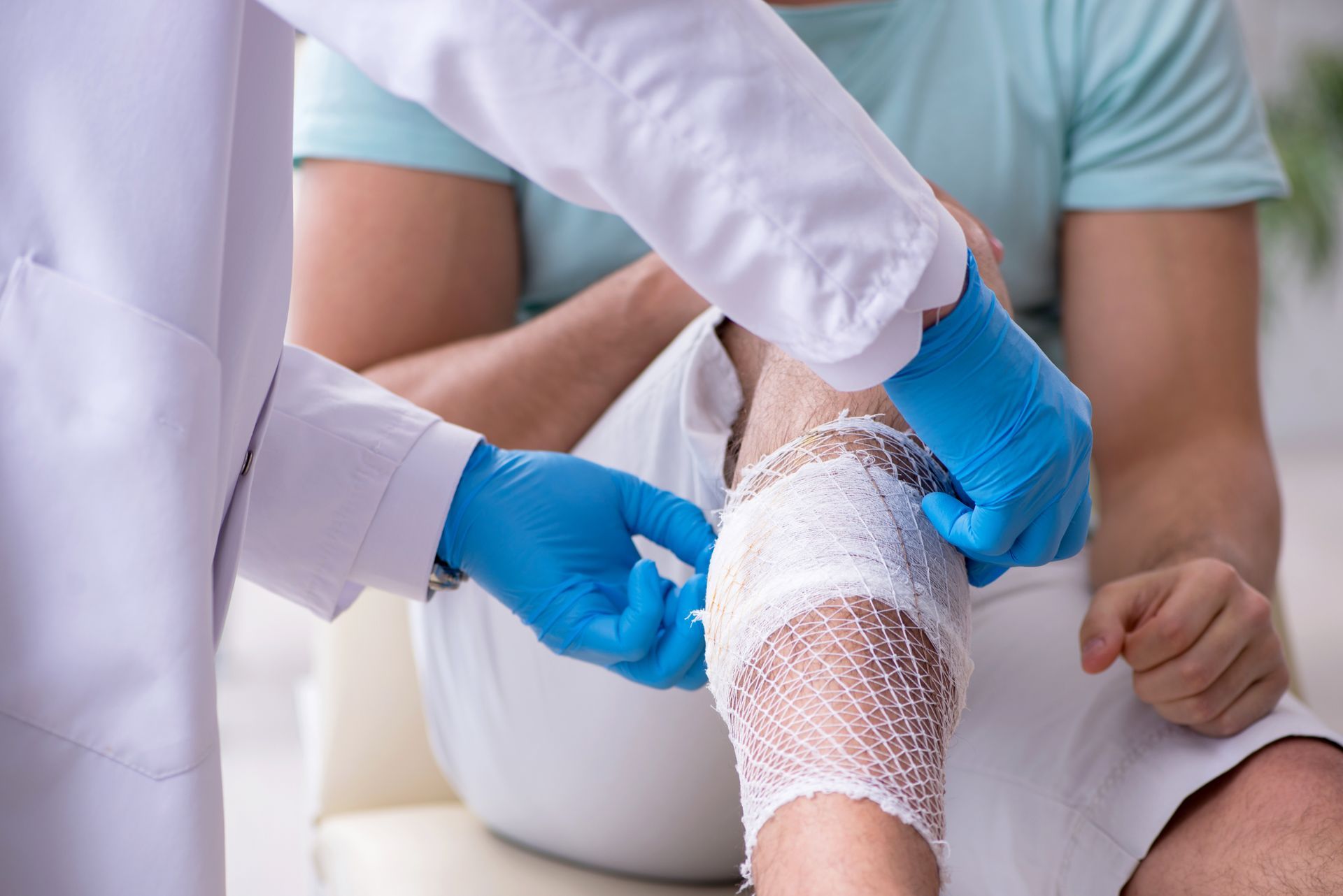 A leg of an injured man being wrapped in gauze by a specialist