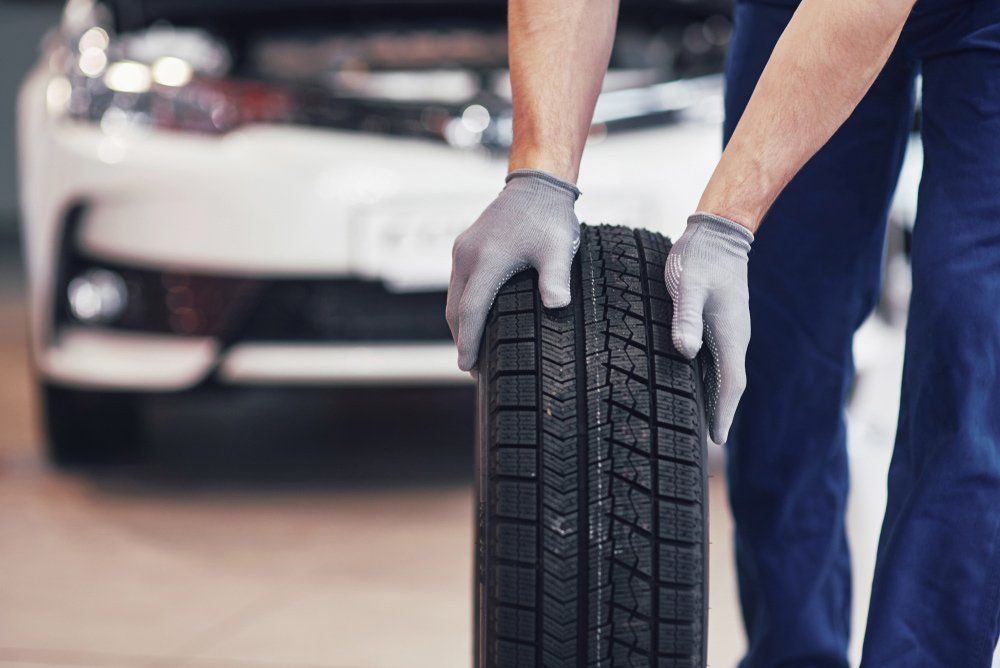 Mechanic holding a tire — Mechanic Near Me in Pokolbin, NSW