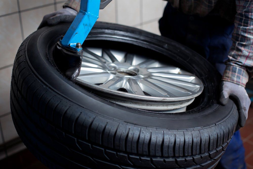 Mechanic removes car tire closeup — Mechanic Near Me in Muswellbrook, NSW