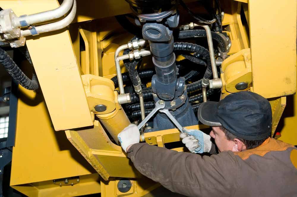 Repairman Doing A Heavy Machine Repair And Maintenance