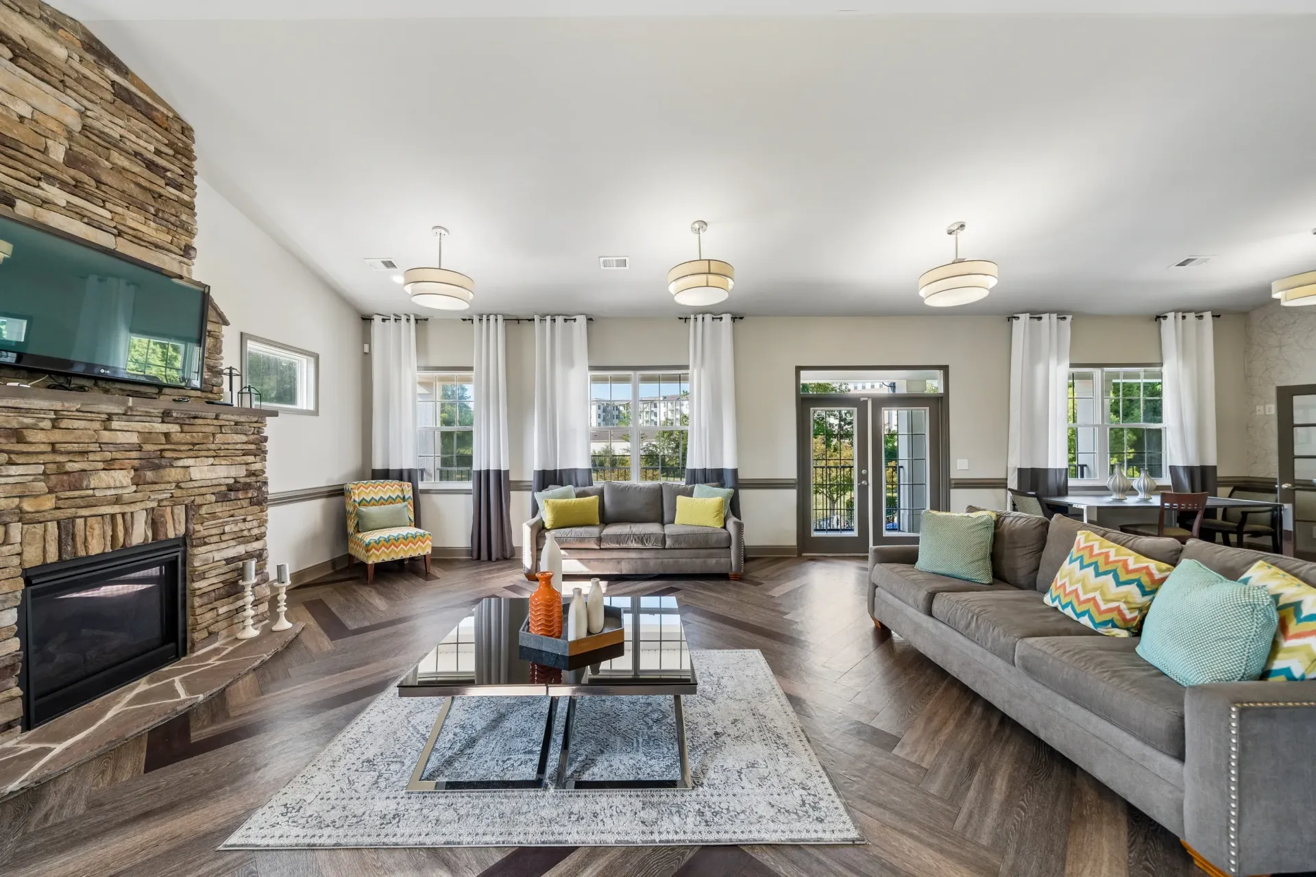 Clubhouse living area with a stone fireplace, multiple sofas, and a coffee table.