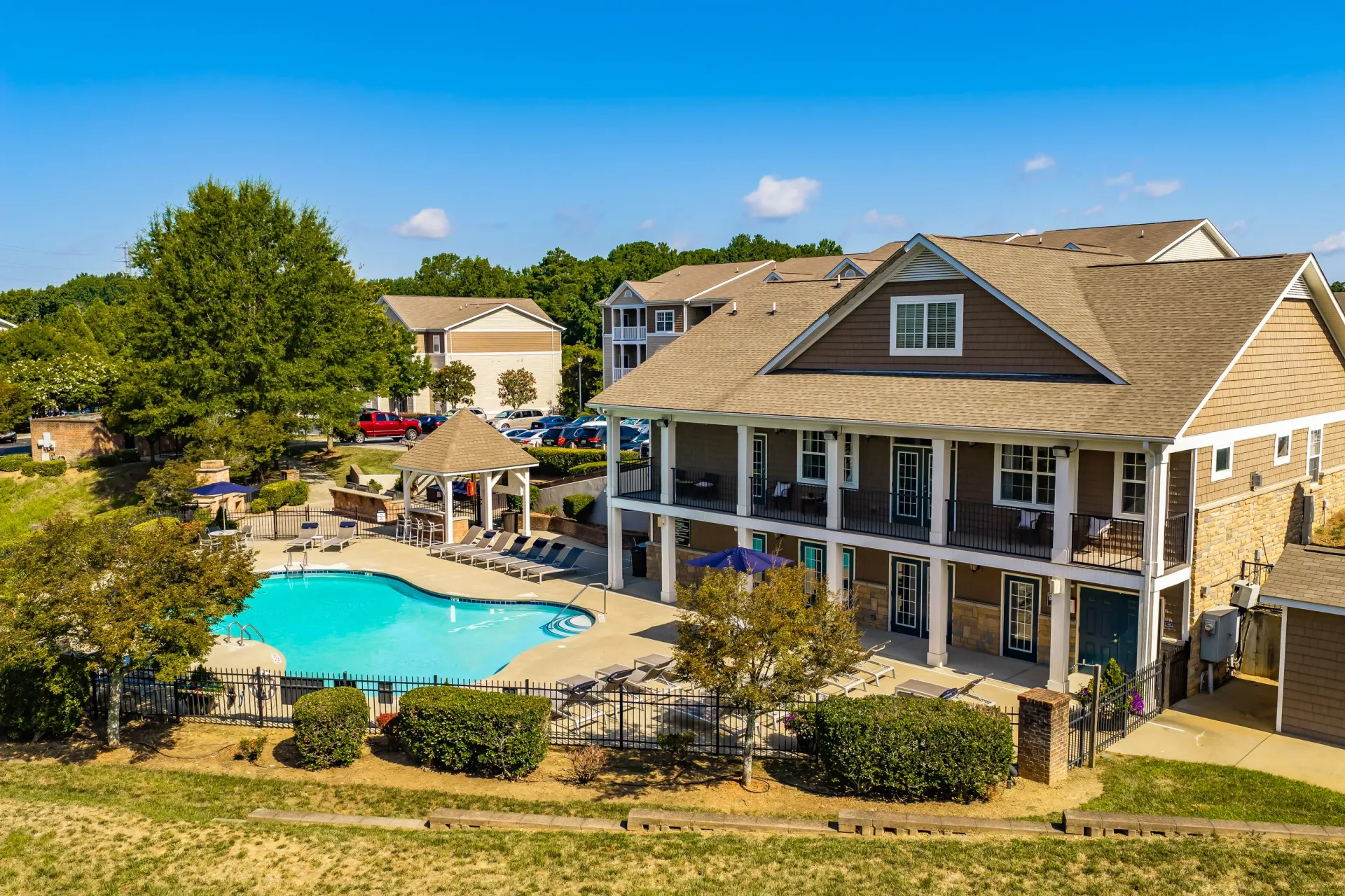 Resort-style swimming pool and clubhouse at a multifamily property.