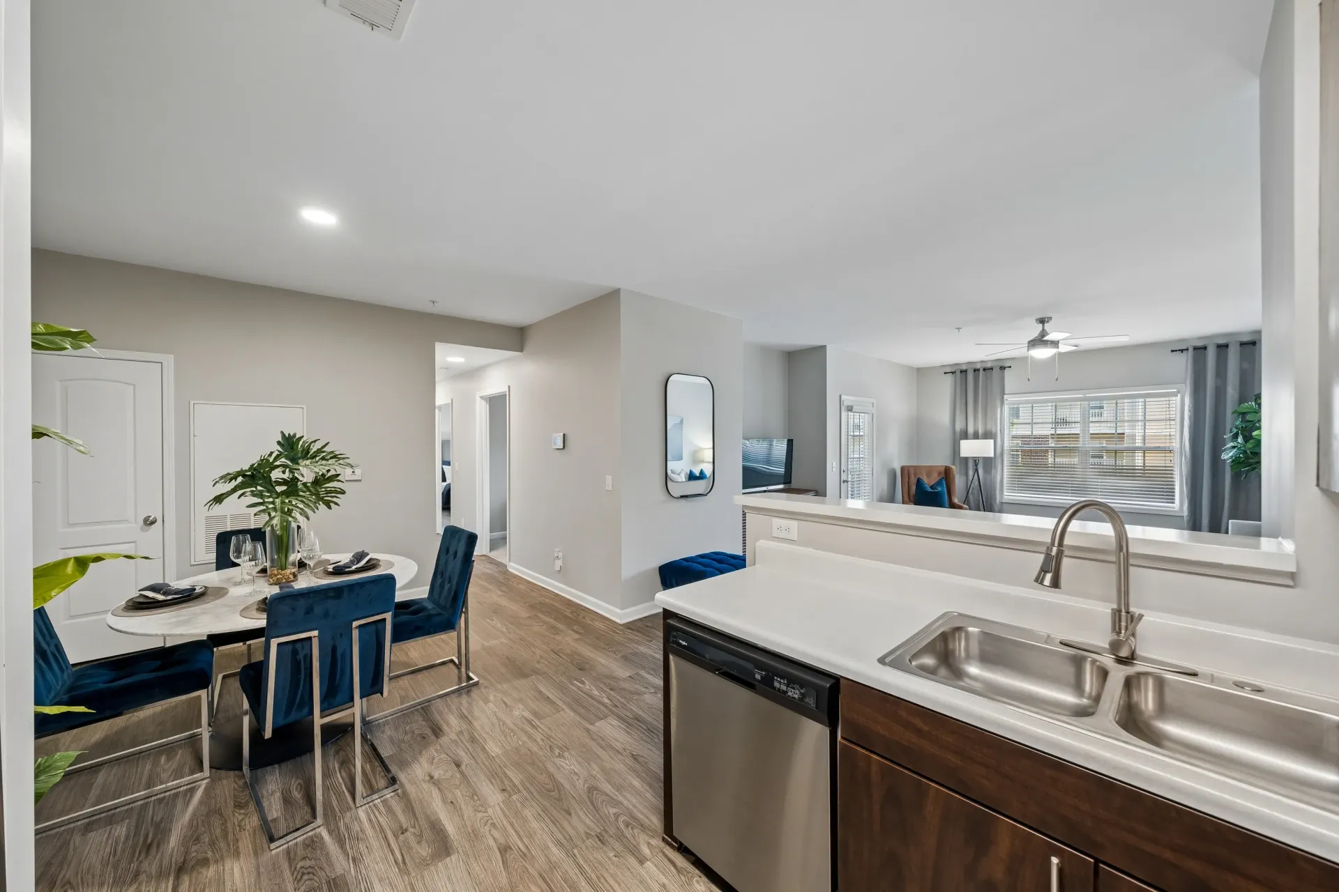 Dining area with a table and chairs, leading into a living room with a TV and sofa.
