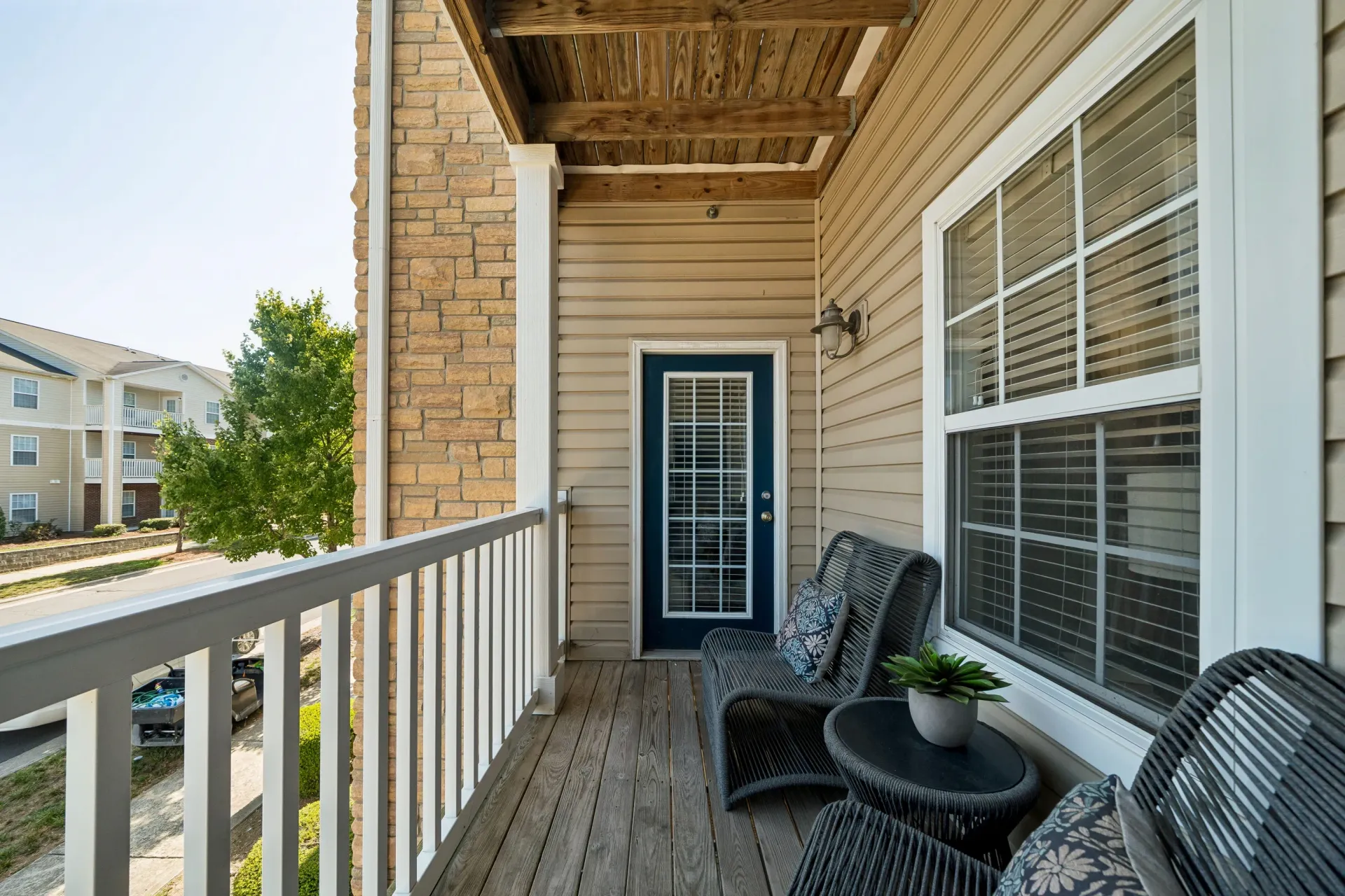 Balcony with seating and a view of the apartment buildings and street.
