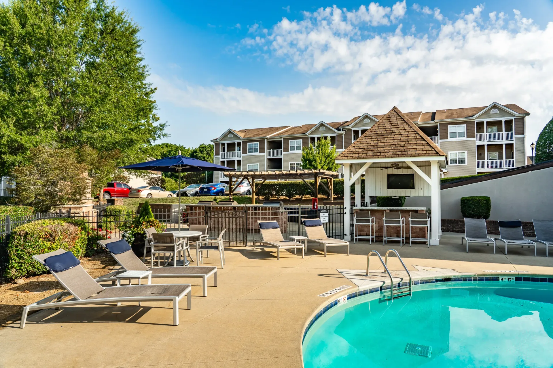 Outdoor swimming pool with lounge chairs and cabana bar.