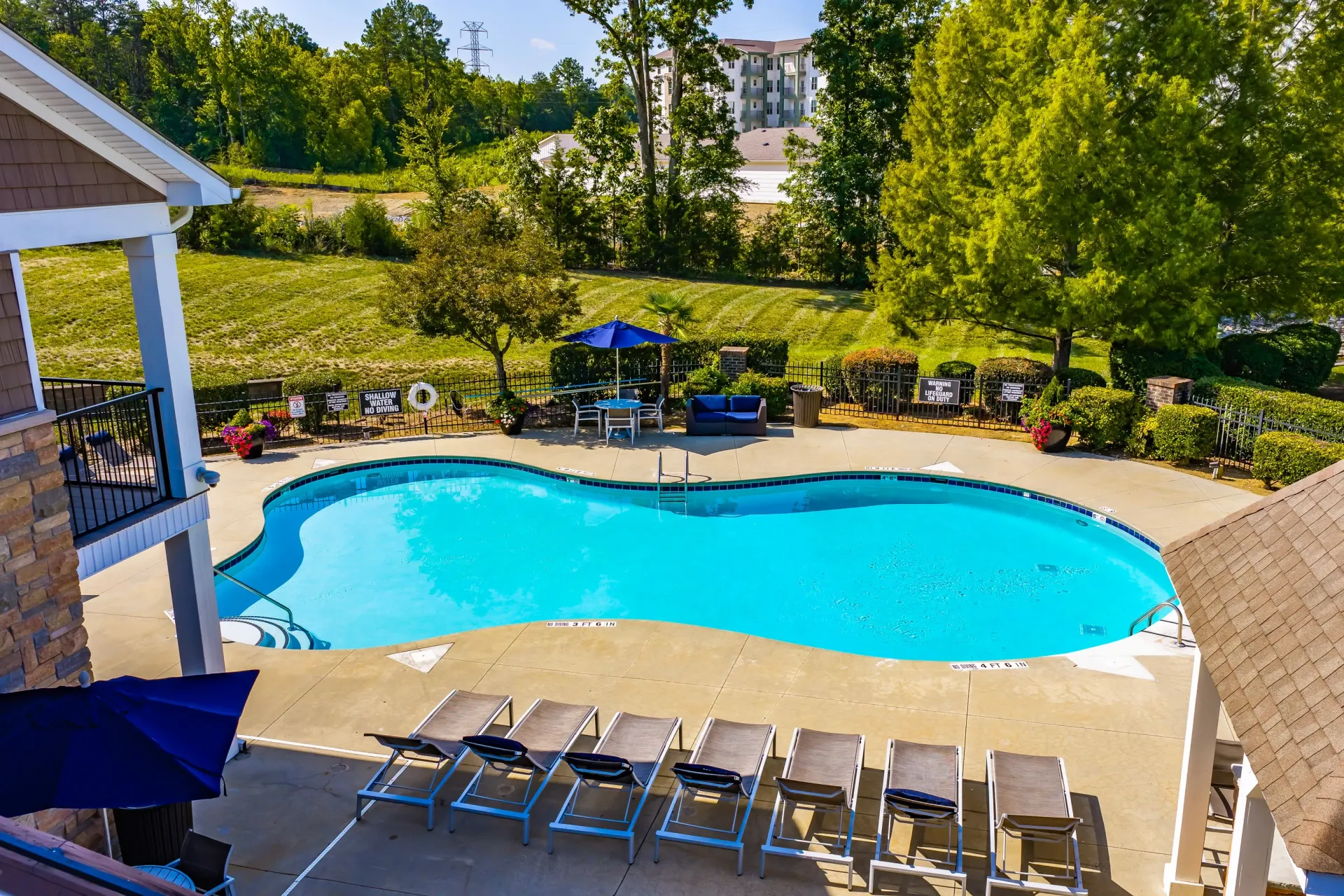 Resort-style swimming pool with lounge chairs and umbrellas.