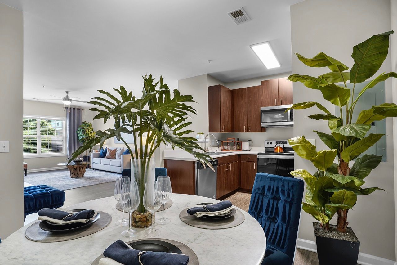 Open-concept dining area with a marble table, blue chairs, and a visible kitchen at Reserve at Stone Hollow in Charlotte, NC.