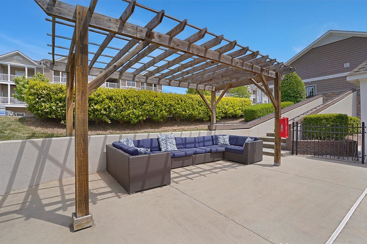 Outdoor seating under a wooden pergola at a multifamily community at Reserve at Stone Hollow in Charlotte, NC.