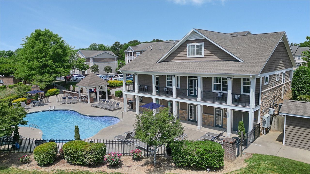 Outdoor community pool with lounge chairs and a gazebo, beside a two-story residential building at Reserve at Stone Hollow in Charlotte, NC.