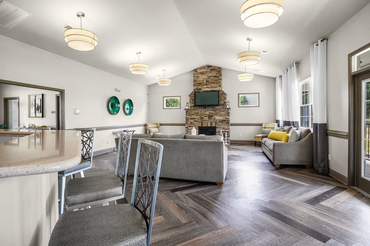 Indoor community lounge with a stone fireplace, TV, and seating area at Reserve at Stone Hollow in Charlotte, NC.