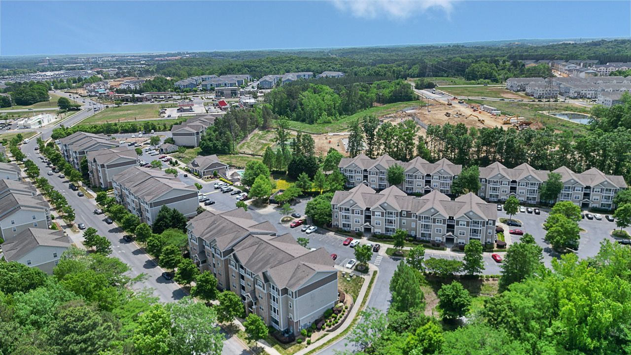 Aerial view of a large apartment community with multiple buildings, parking lots, and trees at Reserve at Stone Hollow in Charlotte, NC.