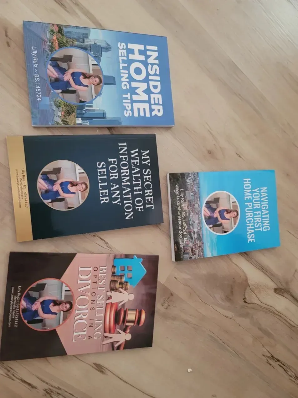 Four real-estate books by Lilly Ruiz on a wooden table, featuring home sales and moving services.