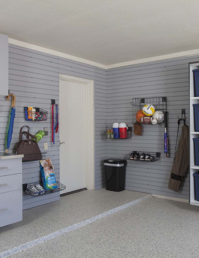 Gray utility room with wall-mounted storage shelves, cleaning supplies, and a closet door