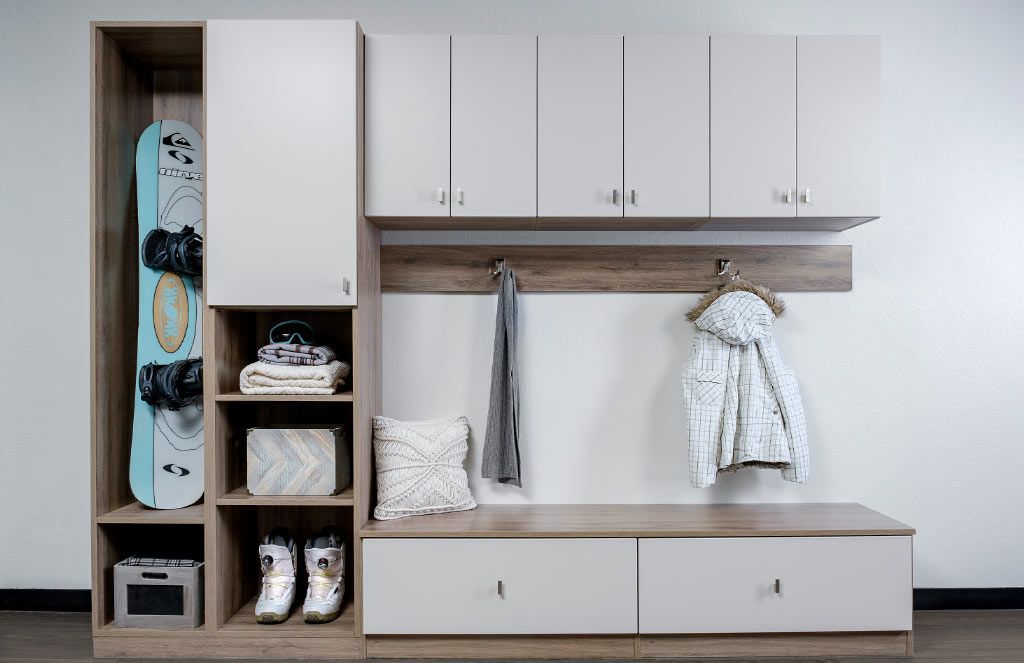 a mudroom with a snowboard hanging on the wall and a coat hanging on the wall .