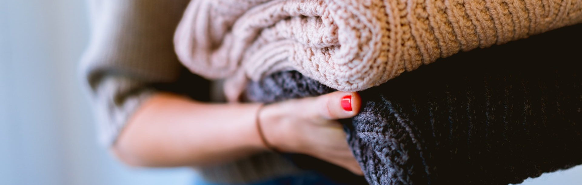 Woman Carrying Folded Sweaters