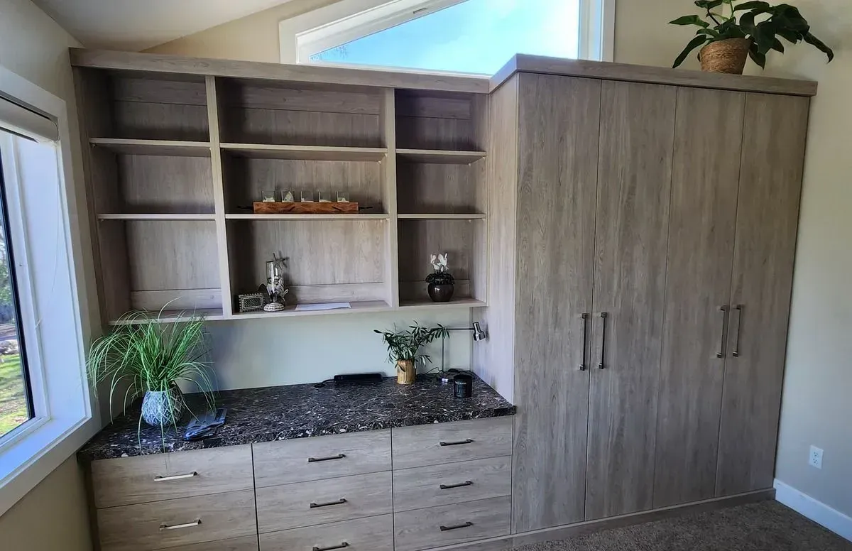 a walk in closet with lots of clothes and two ottomans